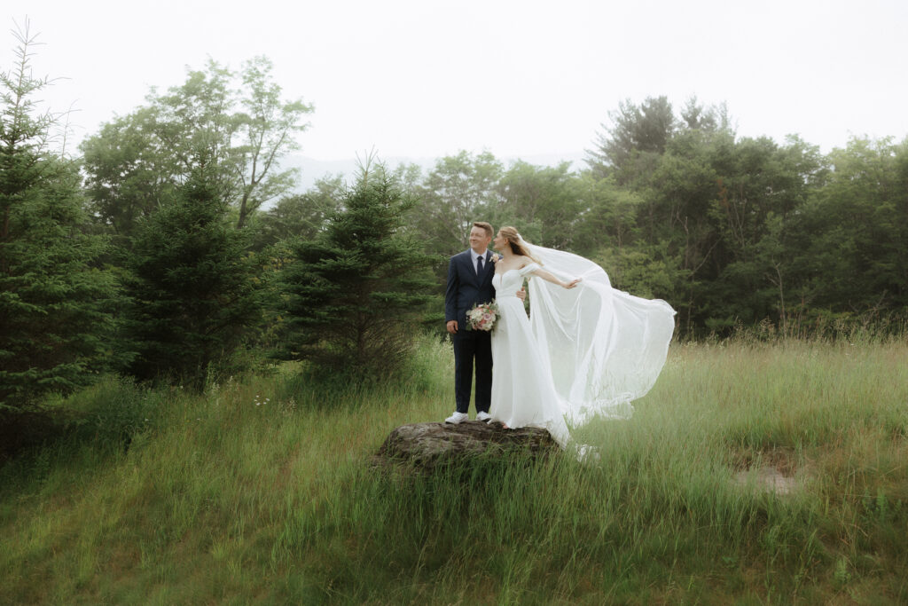 bride and groom in grassy field in Stowe, Vermont