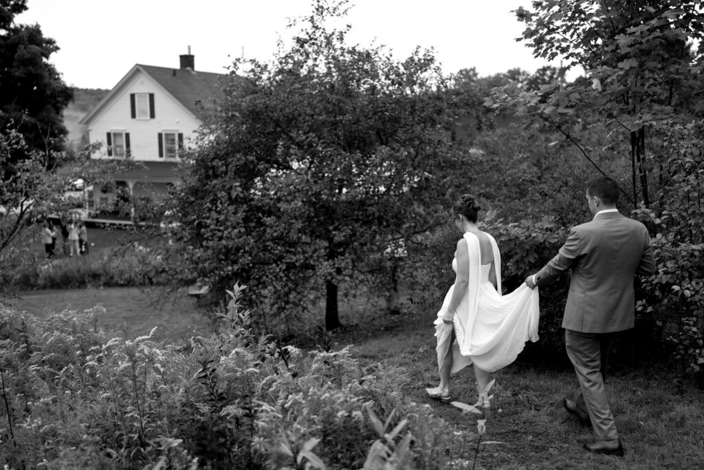 new england wedding , bride and groom walking together to their venue at the Highland Lodge in Greensboro Vermont in Septmeber
