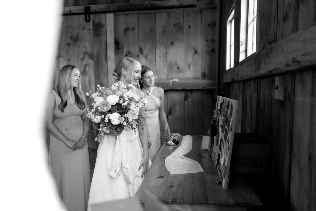 Bride and bridesmaids looking through memory display at Vermont wedding