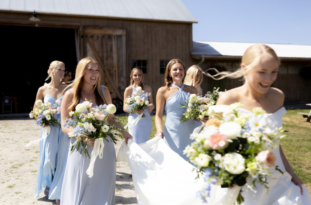 Bride with bridesmaids in soft, coordinated dresses at Vermont summer wedding