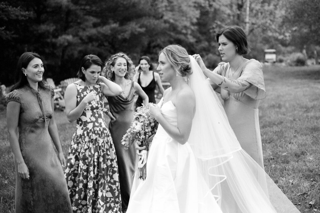Bridesmaids adjusting the bride’s veil during wedding morning preparations
