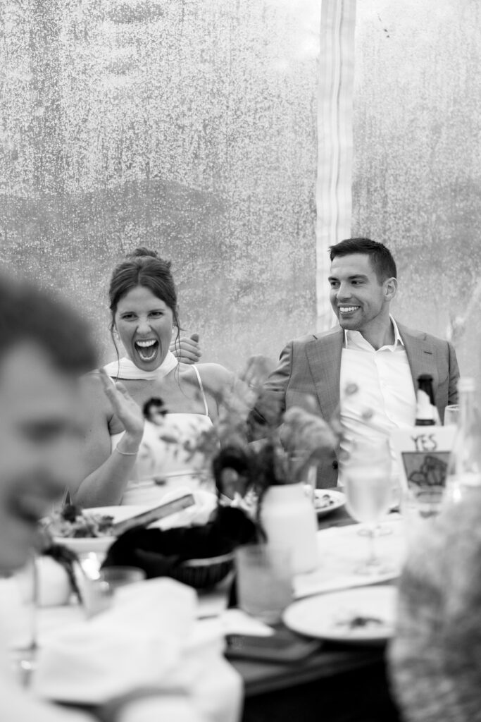 Couple laughing together during dinner at their Vermont wedding reception