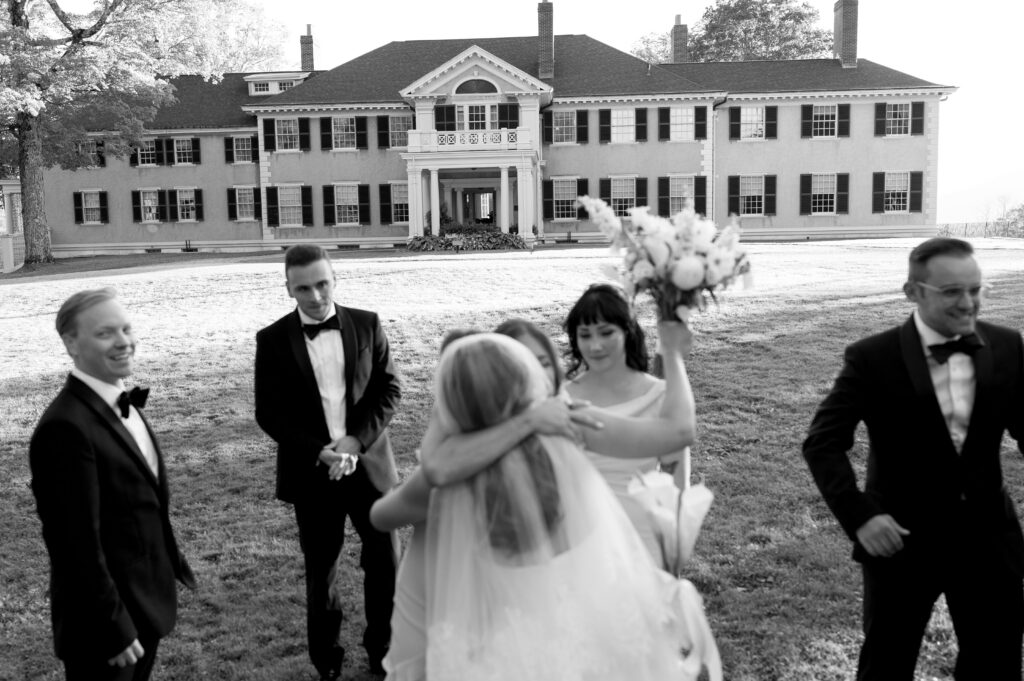 documentary wedding photo of bride hugging bridesmaids